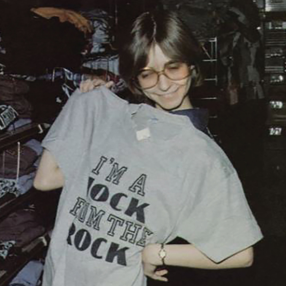 old photograph of a Slippery Rock student holding a gray shirt that reads “I'm a Rock from the Rock”