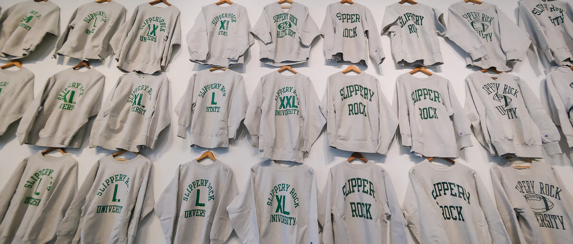 vintage Slippery Rock crewnecks hung on a wall