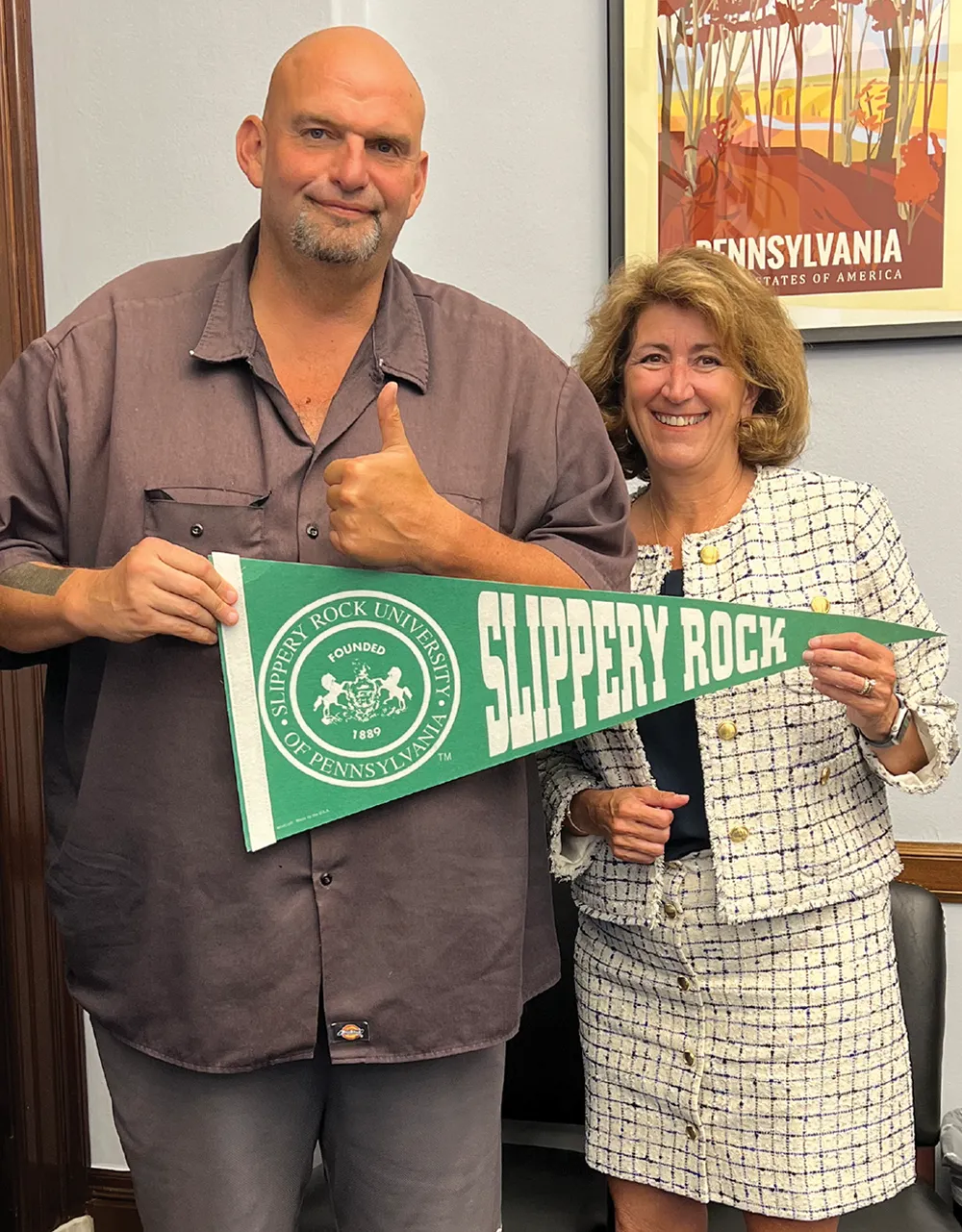 man and woman holding a Slippery Rock pennant