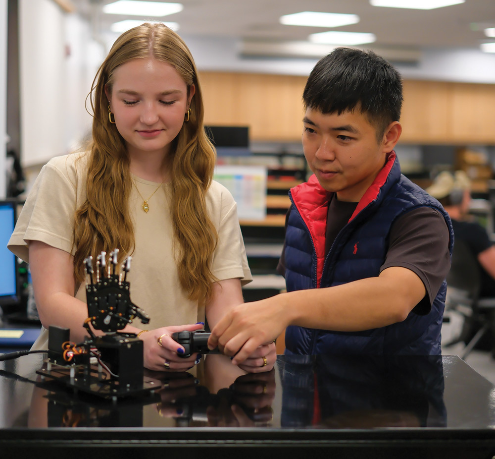 two students using a Playstation controller to work on an engineering project