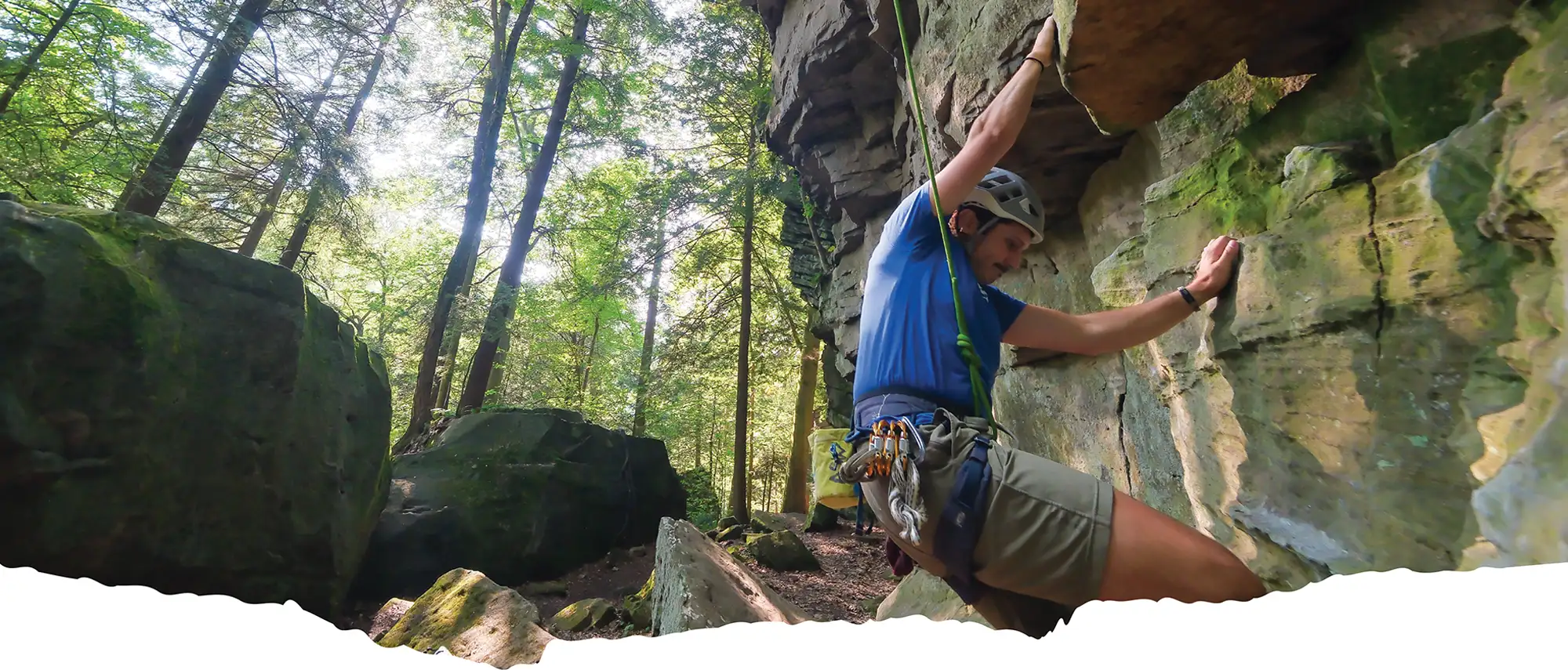 Alex Witmer scaling a rock wall outdoors