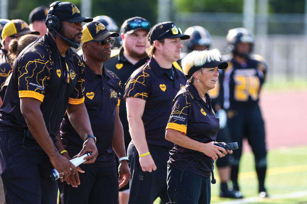 Teresa Conn holding her headset in both hands while coaching a game for the Pittsburgh Passion