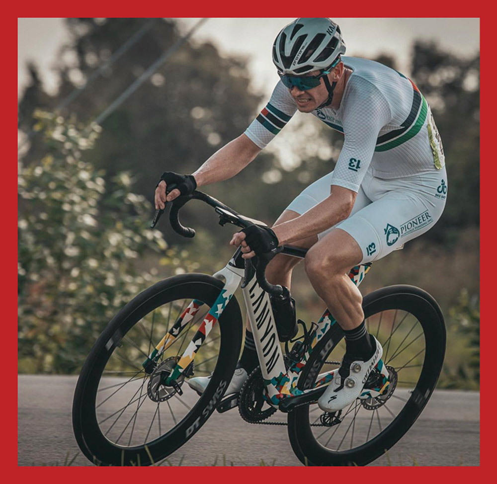 Eric McBride wearing white gear and riding his bike