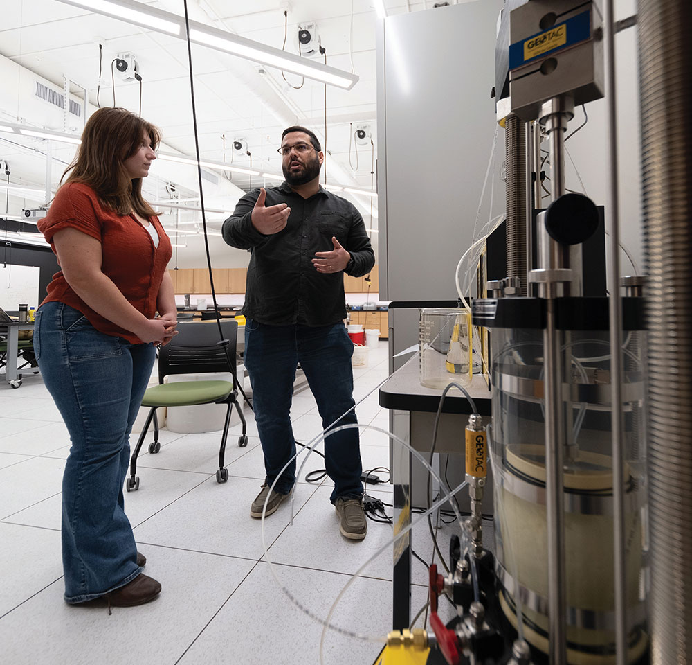 low angle view of student Ashley Rimmel and professor Iuri Santos in deep discussion while in a lab