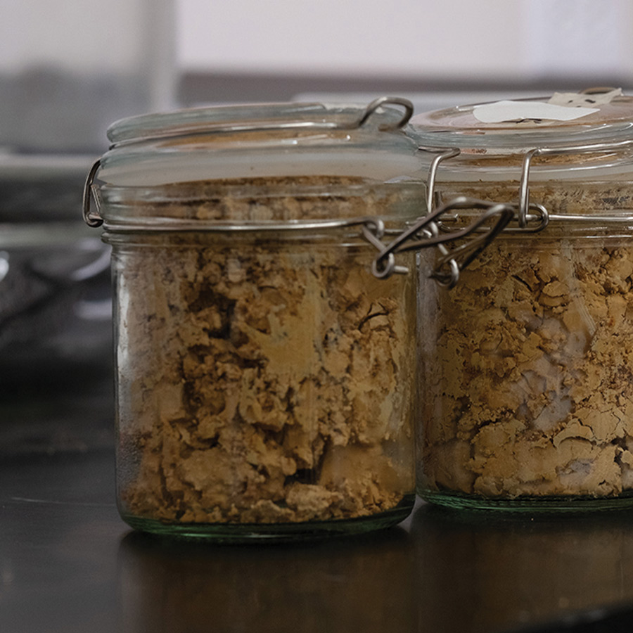 close cropped view of small glass jars filled with sludge from an acid mine