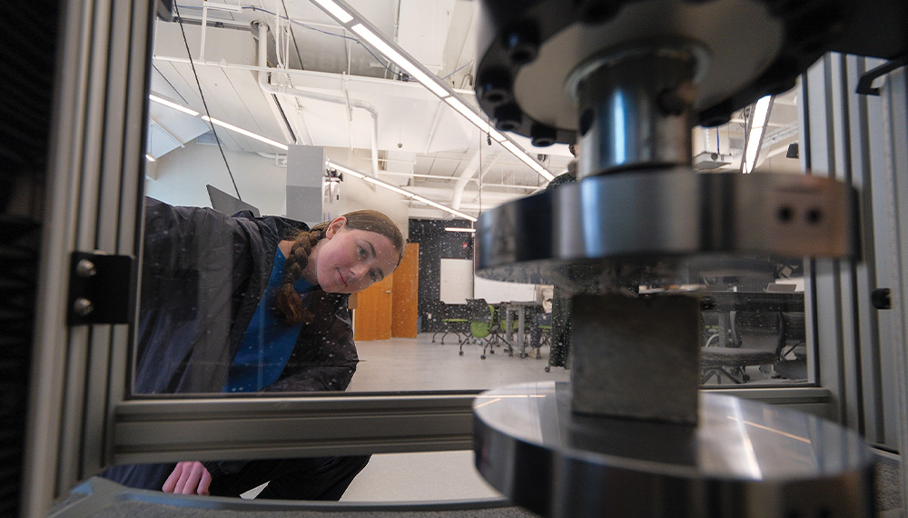 viewed from inside the Instron Universal Testing Machine, student Amber Maurer tests the amount stress of a cement-based composite