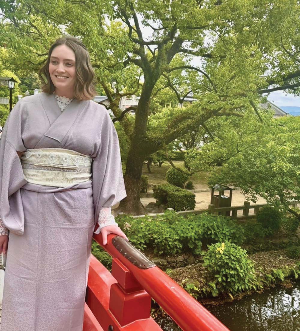 Aria Kriebel standing on bridge and wearing a light purple kimono