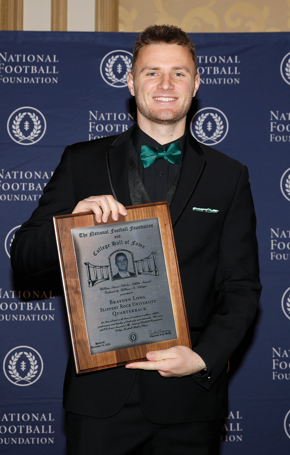Brayden Long holding plaque and smiling