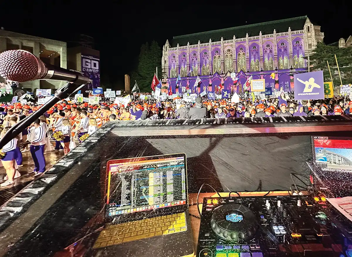 fans gathered for College GameDay with an open laptop and DJ turntables in the forefront