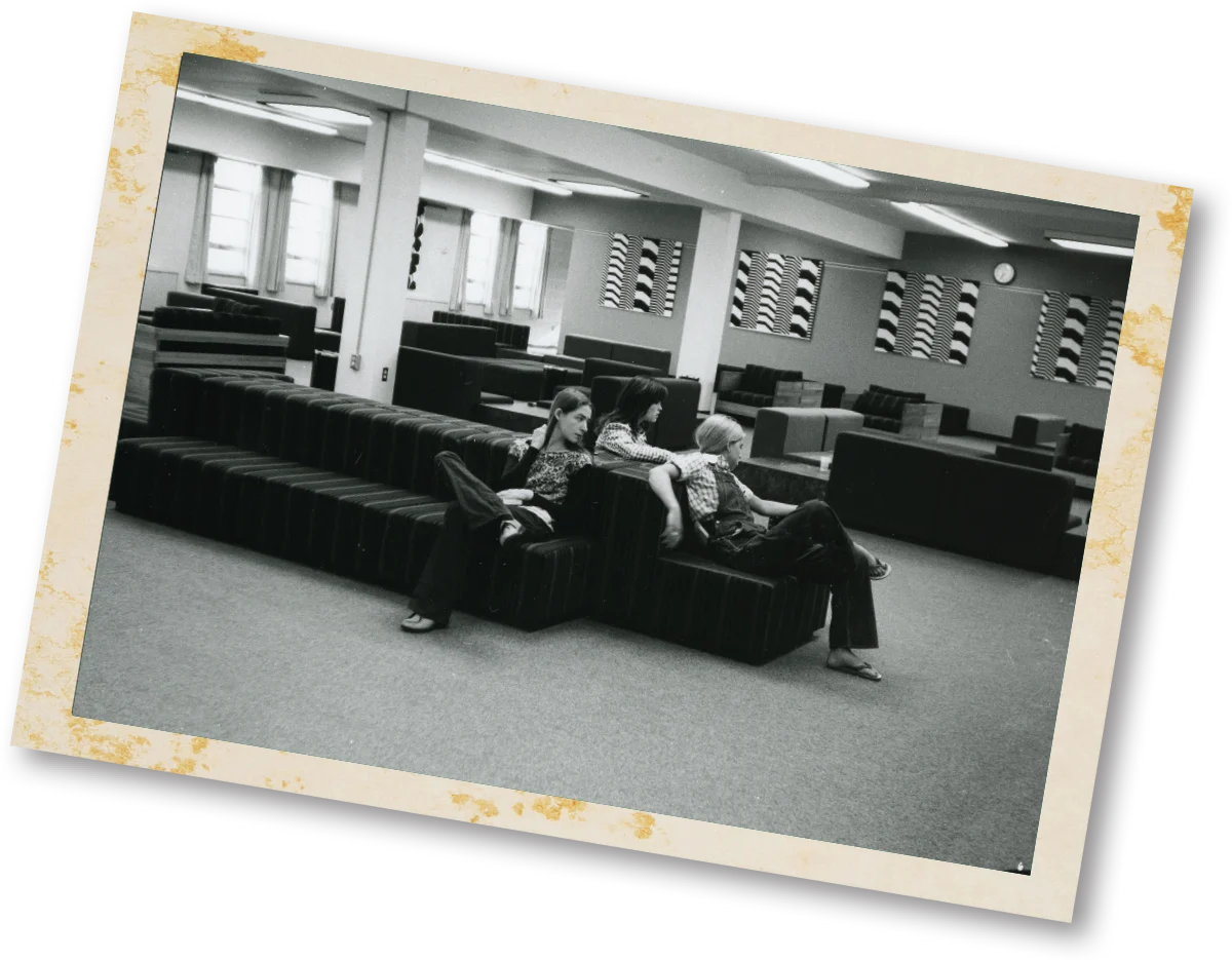black and white photo of students lounging on sofas at the University Union