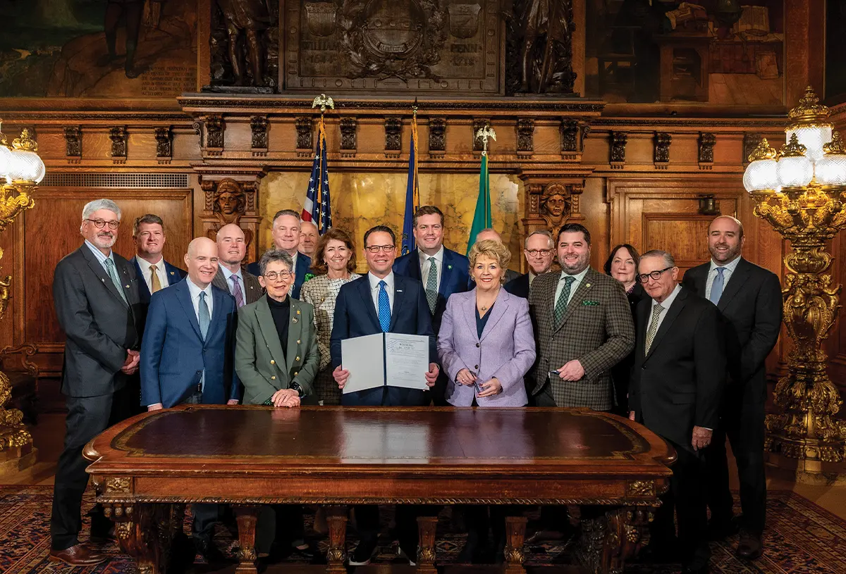 group of people in business attire posing with a certificate at a table