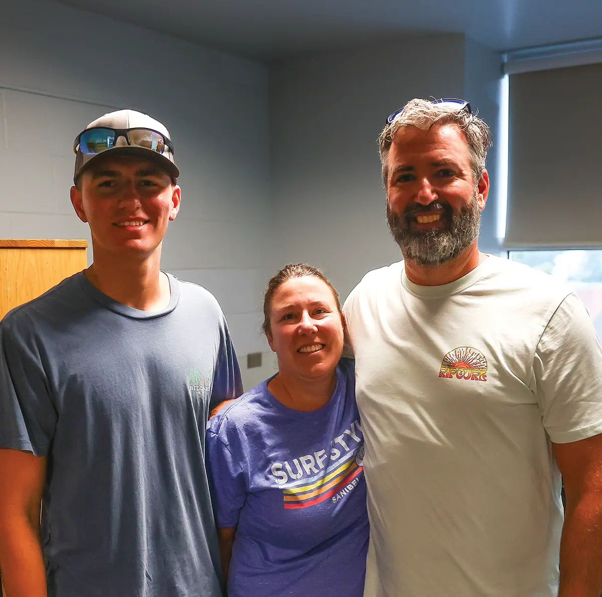 Tristen Saeler, a young guy wearing a graphic t-shirt and a hat with sunglasses situated on top, is seen accompanied by his parents, Samantha and Bryan Saeler, on Slippery Rock University's (SRU) move-in day