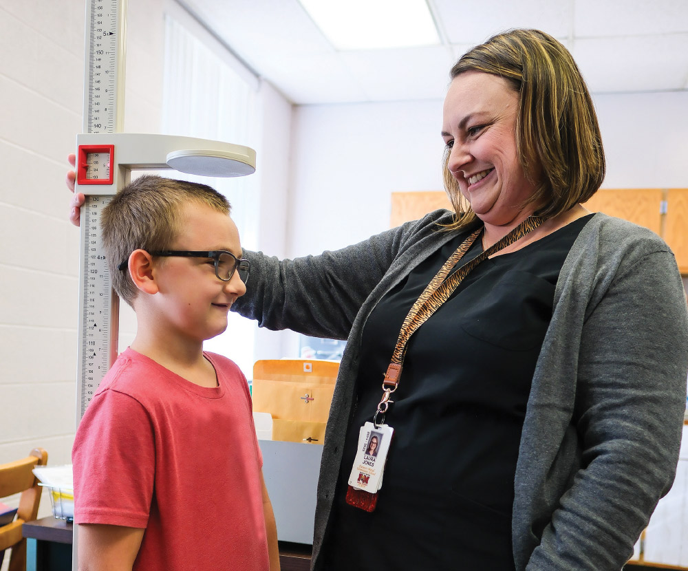 Nurse Laura Jones measuring a students height