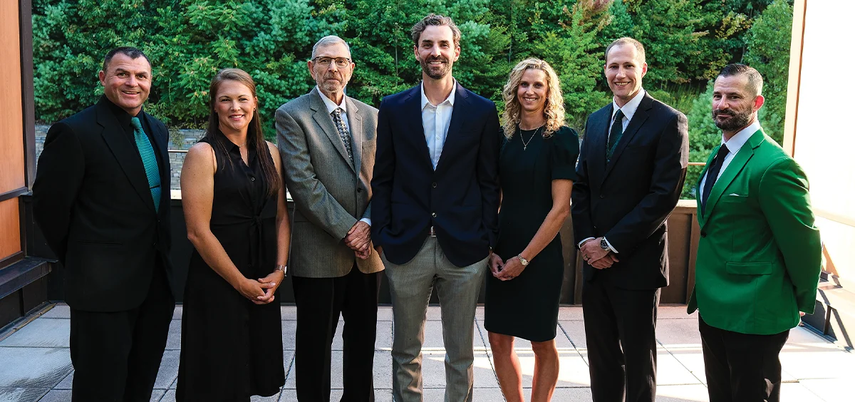 Members of the SRU Athletics Hall of Fame Class of 2025 posing together wearing business attire